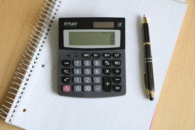 Kalkulator i długopis na notatniku
